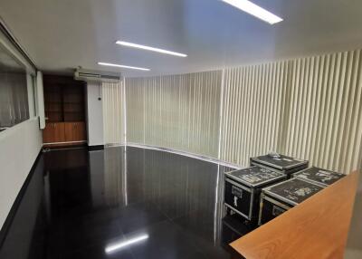 Modern office space with AC, black flooring, and large windows with vertical blinds