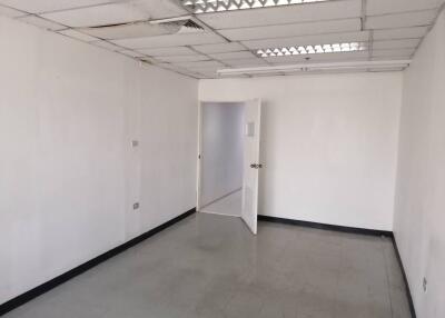 Empty room with white walls, ceiling lights, and an open door