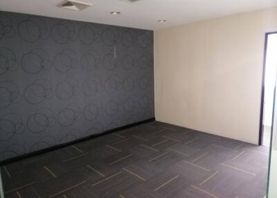 empty room with patterned accent wall and tile flooring