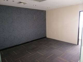 empty room with patterned accent wall and tile flooring