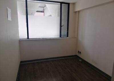 Empty room with large window and wooden flooring