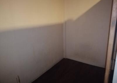 Empty room with bare walls and dark flooring