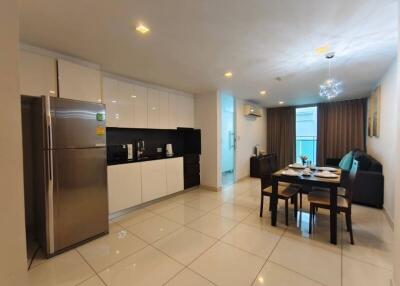 Modern kitchen and dining area with tiled floor, equipped with appliances and a dining table.