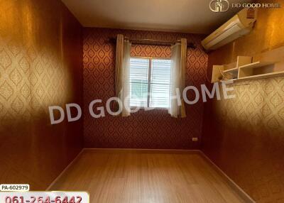 Empty bedroom with patterned wallpaper and wood flooring