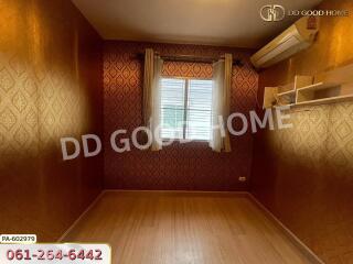 Empty bedroom with patterned wallpaper and wood flooring