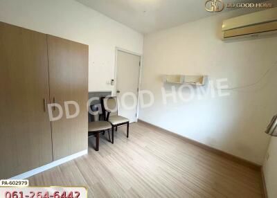 Minimalist bedroom with wooden wardrobe, air conditioning, and seating