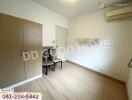 Minimalist bedroom with wooden wardrobe, air conditioning, and seating