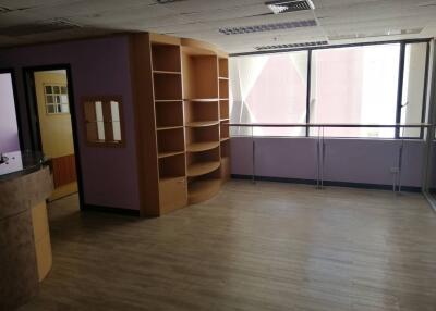 Spacious living area with large windows and built-in shelving