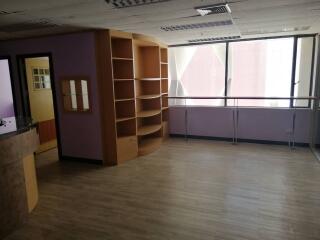 Spacious living area with large windows and built-in shelving