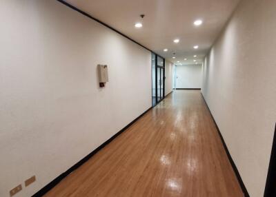 Well-lit hallway with wooden flooring