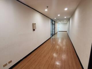 Well-lit hallway with wooden flooring