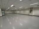 Spacious empty commercial area with tiled floor and ceiling lighting