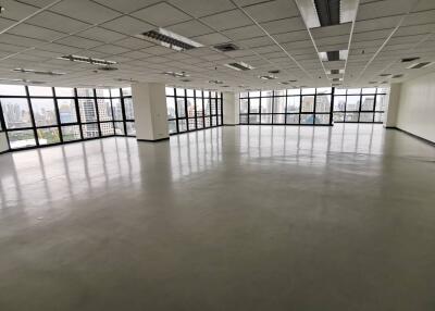 Spacious empty office space with large windows and city views