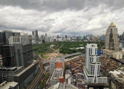 Aerial view of cityscape with modern skyscrapers, park, and construction sites