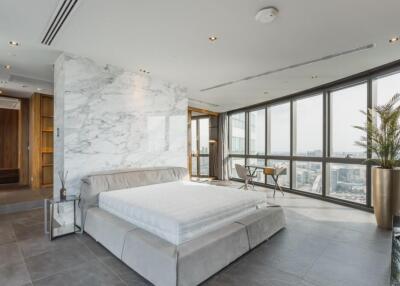 Spacious bedroom with large windows and city view