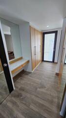 Modern walk-in closet with wooden cabinetry and large mirror