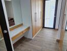 Modern walk-in closet with wooden cabinetry and large mirror