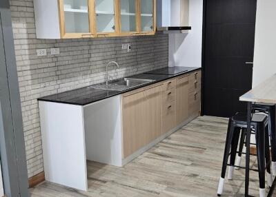 Modern kitchen with wooden cabinets and black countertops