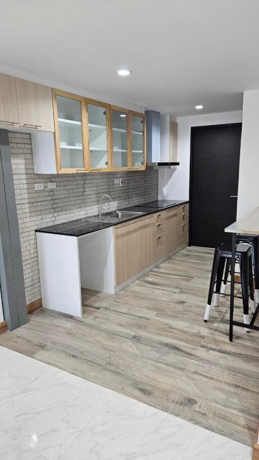 Modern kitchen with wooden cabinets and black countertops