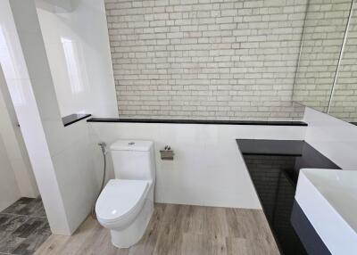 Modern bathroom with white brick wall and sleek fixtures