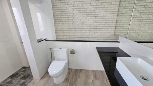 Modern bathroom with white brick wall and sleek fixtures