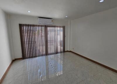 Spacious unfurnished living room with large windows and air conditioning.