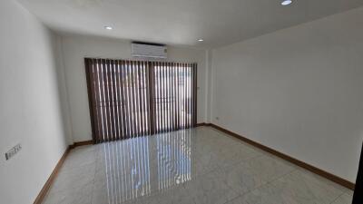 Spacious unfurnished living room with large windows and air conditioning.