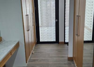 Hallway with wooden flooring and built-in wooden closets