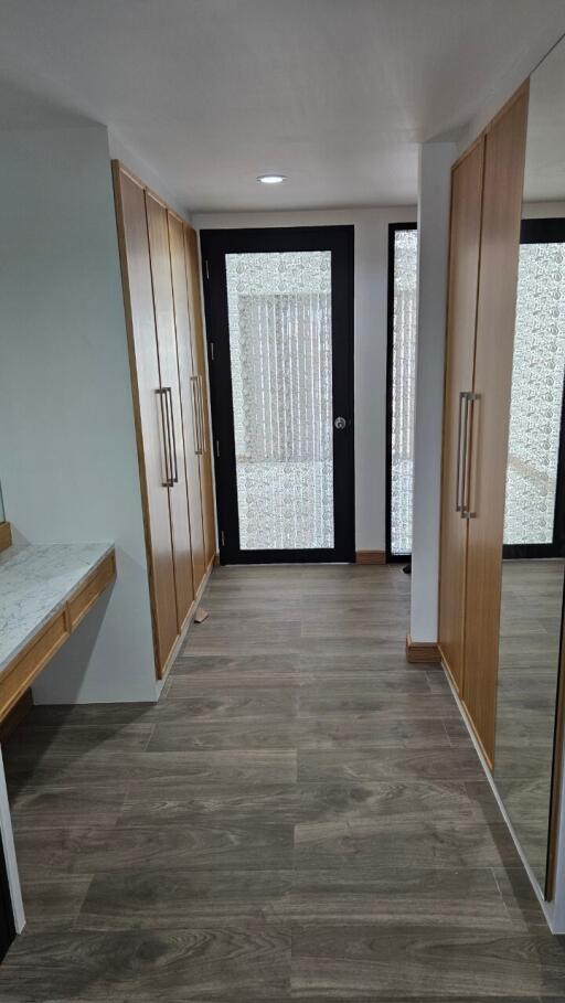 Hallway with wooden flooring and built-in wooden closets