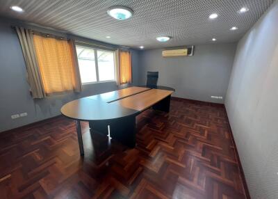 Office room with wooden flooring, desk, and chair