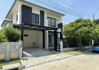 Modern two-story house with driveway and small garden