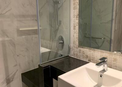 Modern bathroom with sink, shower, and marble tiles