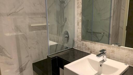 Modern bathroom with sink, shower, and marble tiles