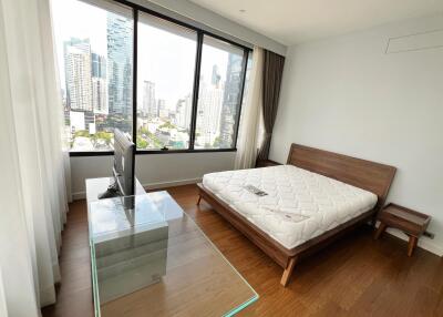 Spacious bedroom with large windows and city view