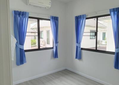 Small bedroom with blue curtains and air conditioning