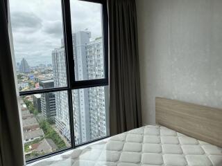 Bedroom with large window and city view