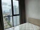 Bedroom with large window and city view