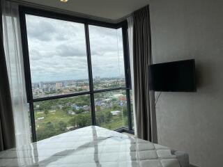 Bedroom with large windows and city view