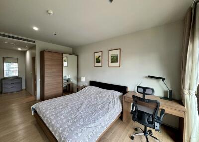 Modern bedroom with a bed, desk, and office chair