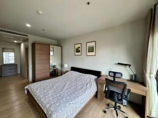 Modern bedroom with a bed, desk, and office chair