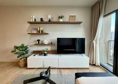 Modern living room with shelves, TV, and balcony