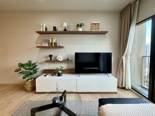 Modern living room with shelves, TV, and balcony