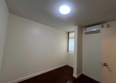 Empty bedroom with white walls, a window, and an air conditioning unit