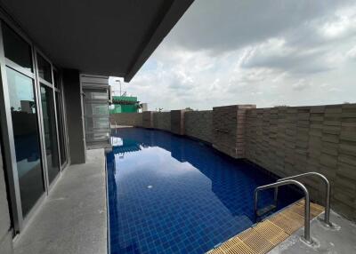 outdoor pool adjacent to building with fenced boundary