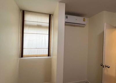 Small bedroom with window and air conditioning unit