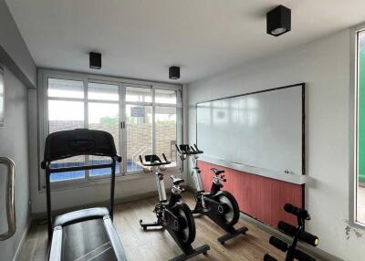 Home gym with exercise equipment including treadmill and stationary bikes