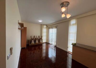 Spacious living room with wooden flooring and large windows