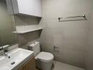 Modern bathroom with sink, toilet, and storage cabinets