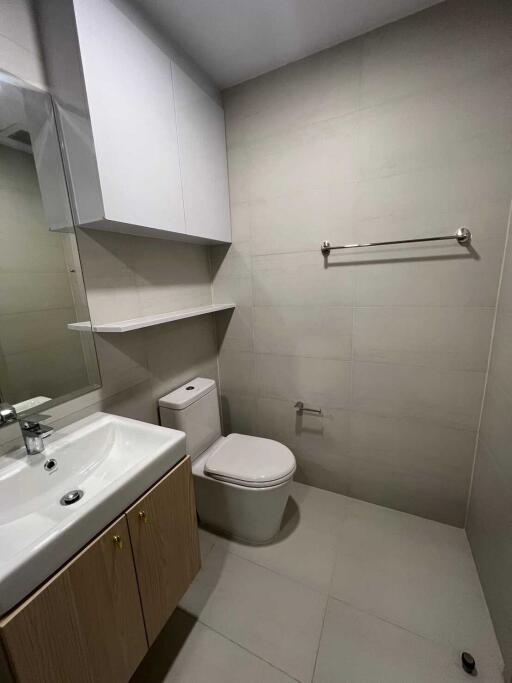 Modern bathroom with sink, toilet, and storage cabinets