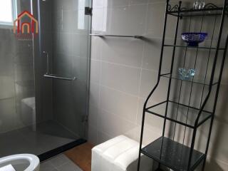 Modern bathroom with glass shower and shelving unit